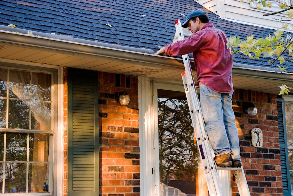 Cleaning the gutters is a part of fall home maintenance.